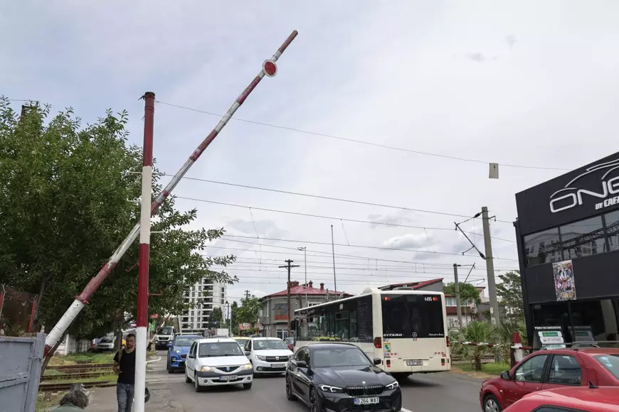 Femeia care ridică cu mâinile o barieră de tren de 36 de ani. O fotografie care reflectă condiția infrastructurii din România.